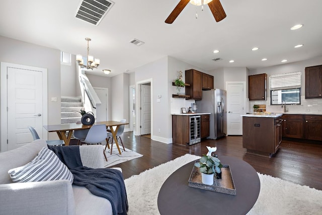 living area with visible vents, dark wood finished floors, and stairs