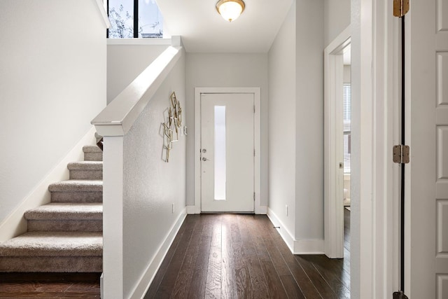 foyer featuring dark wood-style flooring, baseboards, and stairs