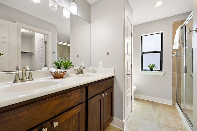 full bath with a stall shower, a sink, toilet, and double vanity