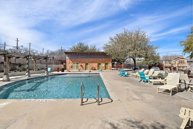 pool with a patio area and fence