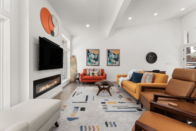 living room featuring a glass covered fireplace, beam ceiling, recessed lighting, and wood finished floors