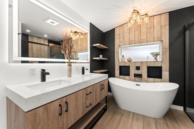 bathroom featuring a freestanding tub, a chandelier, and a sink