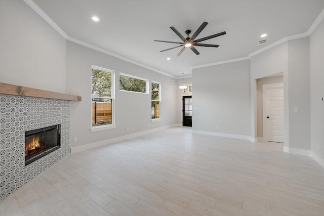 unfurnished living room with ornamental molding, baseboards, visible vents, and a tiled fireplace