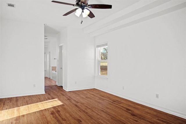 spare room with visible vents, baseboards, wood finished floors, and a ceiling fan