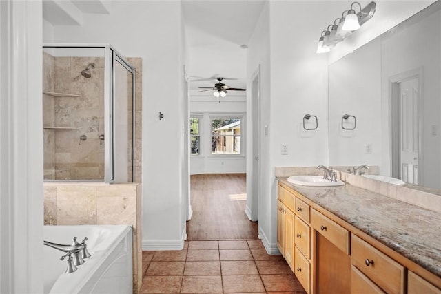 full bathroom featuring a stall shower, tile patterned flooring, a bath, ceiling fan, and vanity