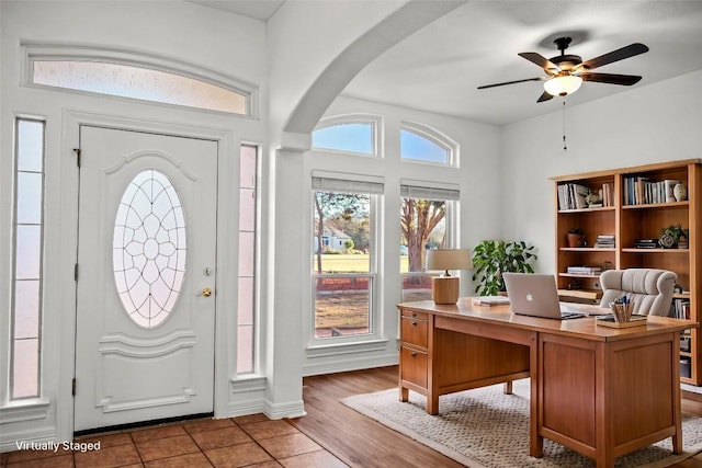 entrance foyer with wood finished floors, arched walkways, and ceiling fan