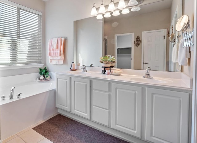 bathroom with double vanity, a sink, a bath, and tile patterned floors