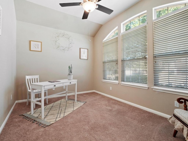 carpeted office space with lofted ceiling, a ceiling fan, and baseboards