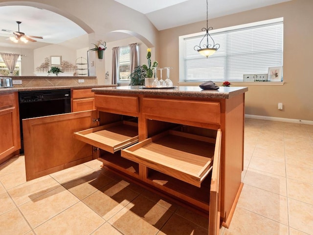 kitchen featuring light tile patterned floors, ceiling fan, a kitchen island, decorative light fixtures, and vaulted ceiling