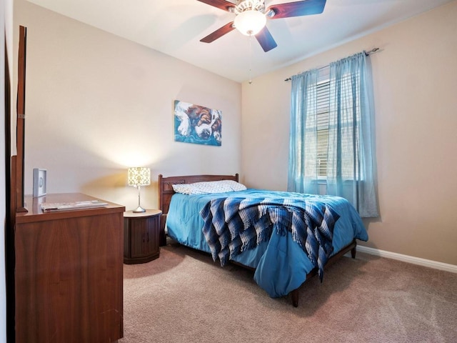 bedroom with ceiling fan, baseboards, and light colored carpet