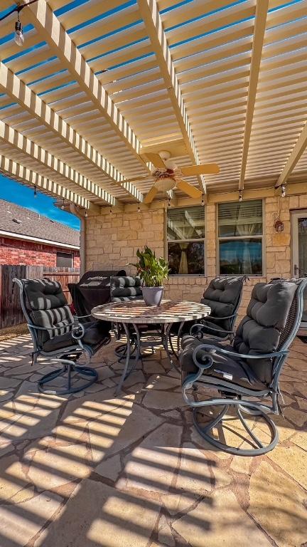 view of patio featuring outdoor dining space, fence, and a pergola