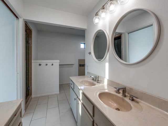 bathroom with double vanity, a sink, a shower with door, and tile patterned floors