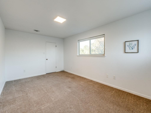 unfurnished room featuring baseboards, visible vents, and carpet flooring