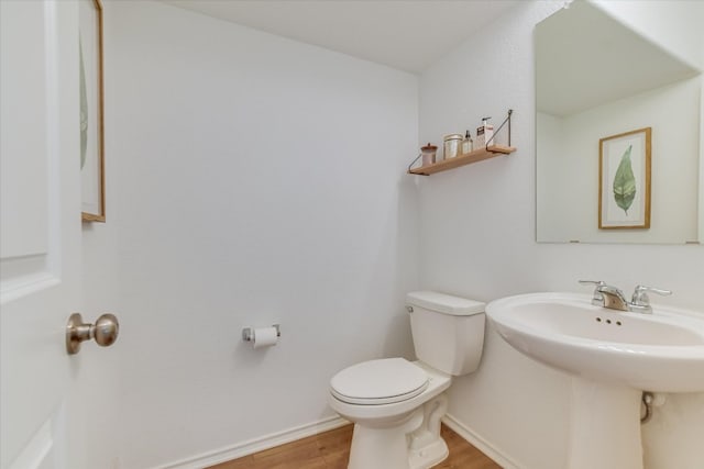 bathroom featuring wood finished floors, toilet, and baseboards