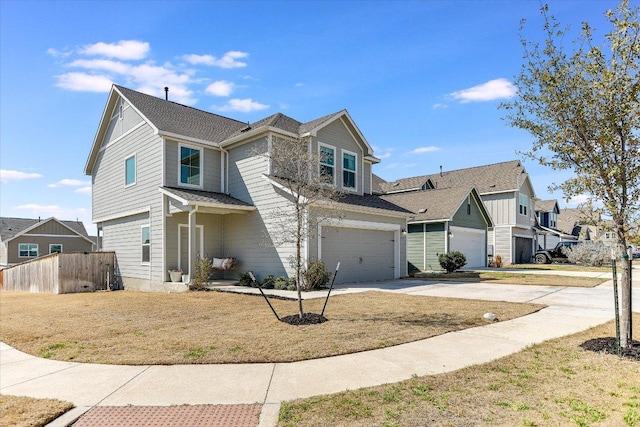 view of front of house featuring a front lawn, fence, a residential view, a garage, and driveway