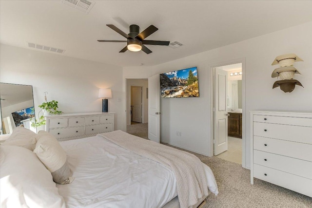 bedroom featuring light carpet, ensuite bath, and visible vents