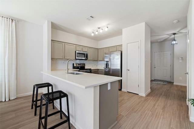 kitchen featuring visible vents, backsplash, gray cabinetry, appliances with stainless steel finishes, and a sink