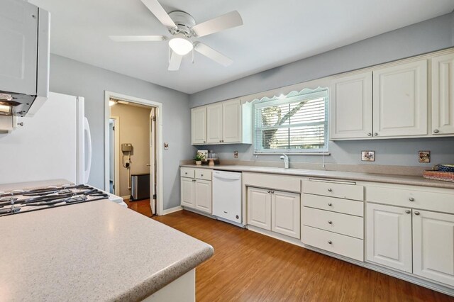2403 Remuda Trl, Austin, TX 78745 - kitchen with white appliances, a sink, light wood-type flooring, ceiling fan, and light countertops