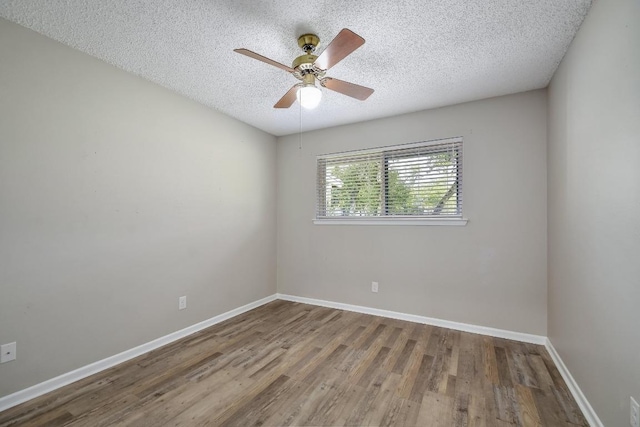 empty room featuring ceiling fan, a textured ceiling, baseboards, and wood finished floors