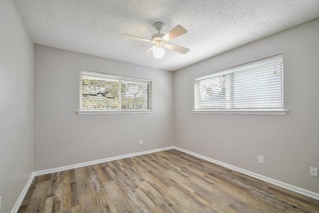 spare room featuring a ceiling fan, a textured ceiling, baseboards, and wood finished floors