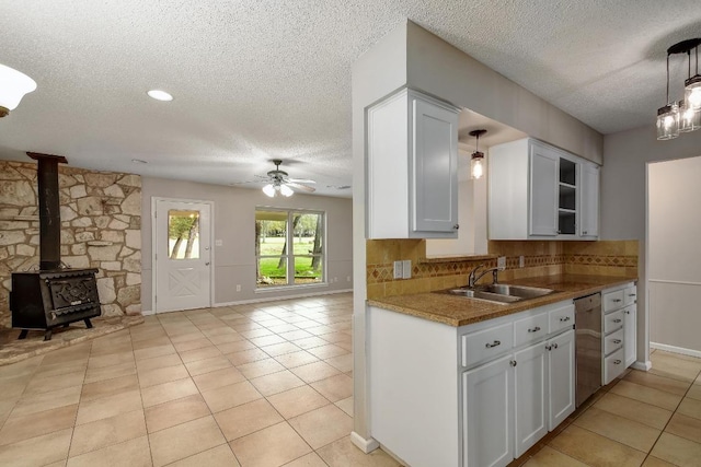 kitchen featuring a sink, white cabinets, open floor plan, backsplash, and dishwasher