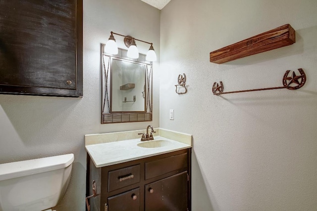 bathroom featuring toilet and vanity