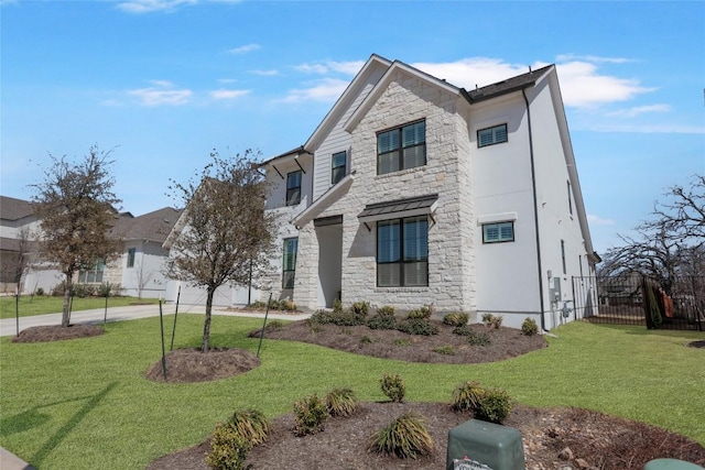 view of front of home featuring a front yard, stone siding, and driveway