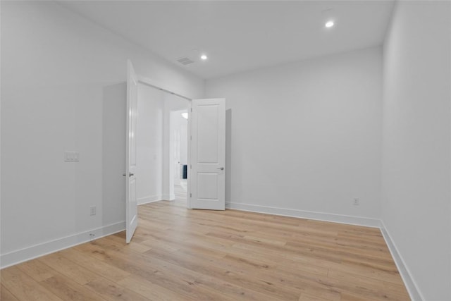 unfurnished room featuring light wood-style floors, baseboards, visible vents, and recessed lighting