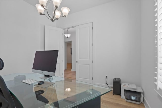 office space featuring a notable chandelier, baseboards, and wood finished floors