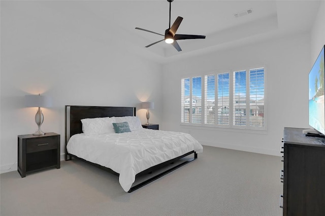 bedroom featuring a tray ceiling, visible vents, carpet flooring, ceiling fan, and baseboards