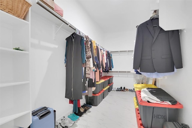 walk in closet featuring marble finish floor