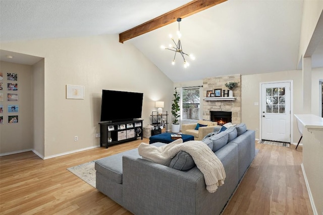 living area with baseboards, lofted ceiling with beams, an inviting chandelier, light wood-style floors, and a fireplace