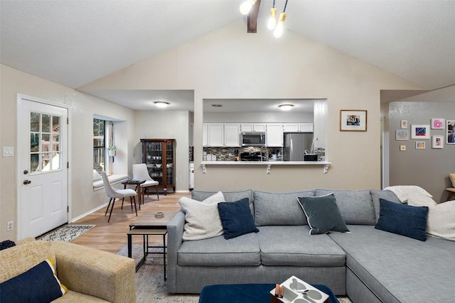 living room featuring high vaulted ceiling, light wood-style flooring, baseboards, and beamed ceiling