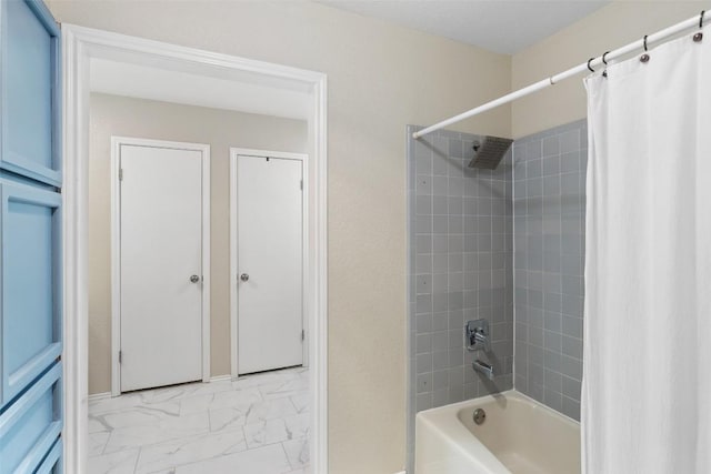 full bathroom featuring marble finish floor and shower / bathtub combination with curtain