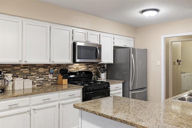 kitchen featuring tasteful backsplash, light stone counters, stainless steel appliances, a textured ceiling, and white cabinetry