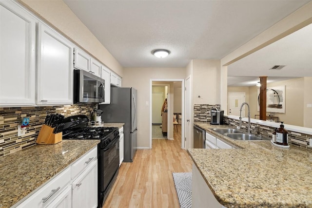 kitchen featuring white cabinetry, tasteful backsplash, appliances with stainless steel finishes, and a sink