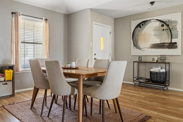 dining room with light wood-style floors and baseboards