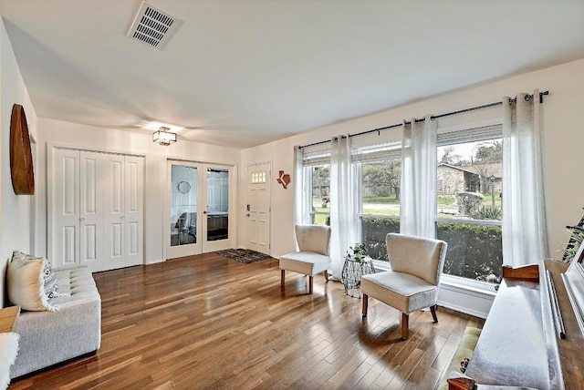 sitting room with french doors, wood finished floors, and visible vents