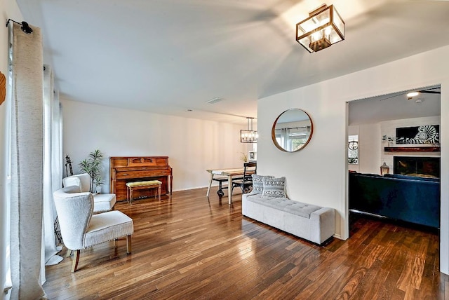 sitting room featuring wood-type flooring, visible vents, and a fireplace