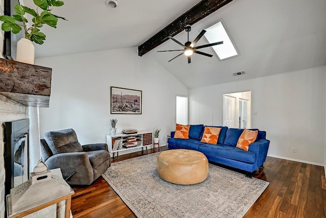 living room featuring vaulted ceiling with skylight, wood-type flooring, a glass covered fireplace, and visible vents