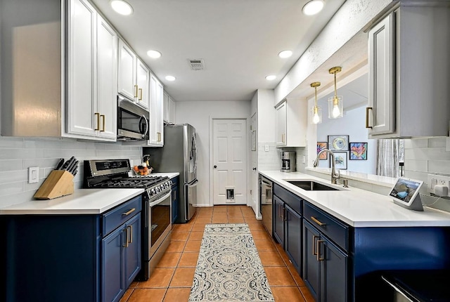 kitchen with light tile patterned floors, stainless steel appliances, a sink, and blue cabinets