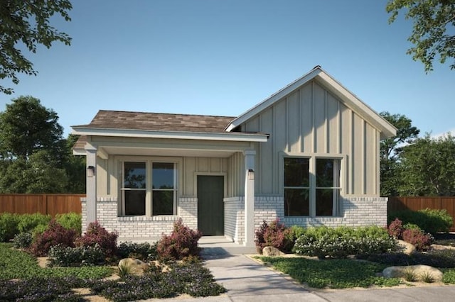 view of front of home with brick siding, board and batten siding, and fence