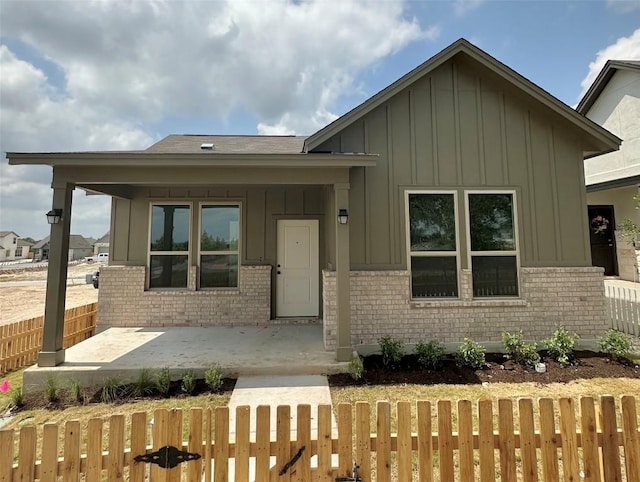 255 Glocken Ln, Kyle, TX 78640 - view of front of property featuring board and batten siding, brick siding, and a fenced front yard