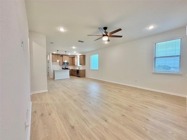 255 Glocken Ln, Kyle, TX 78640 - unfurnished living room with a ceiling fan, baseboards, light wood-style flooring, and recessed lighting