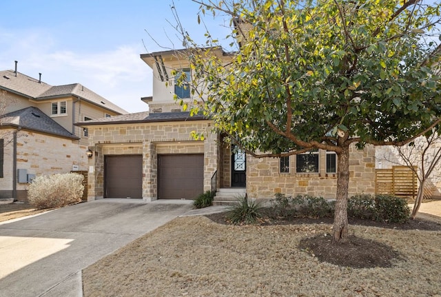 view of front of property with a garage, stone siding, fence, and concrete driveway