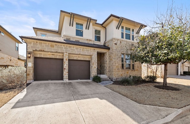 view of front of property featuring concrete driveway, stone siding, an attached garage, fence, and stucco siding