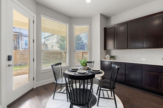 dining area featuring dark wood-style floors, a healthy amount of sunlight, and baseboards