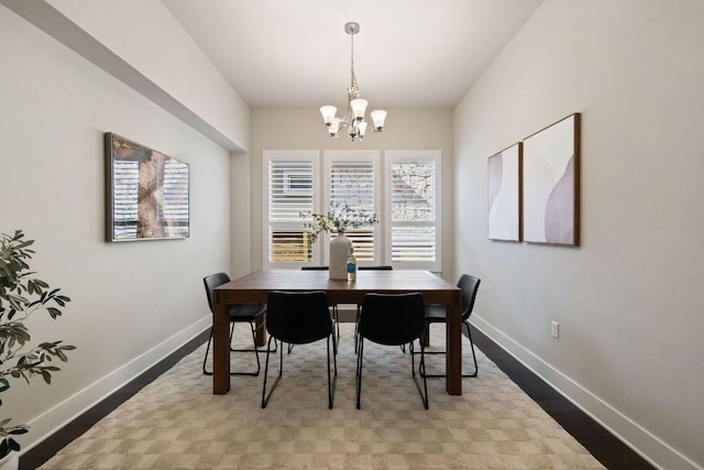 dining room featuring an inviting chandelier, baseboards, and wood finished floors