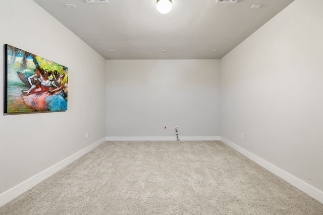 carpeted empty room featuring visible vents and baseboards