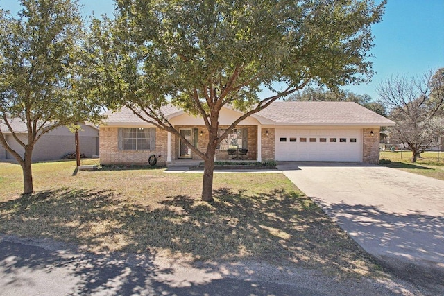 single story home featuring a garage, driveway, brick siding, and a front lawn